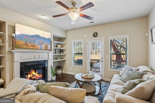 7420 Glisten Ave, Sandy Springs, GA 30328 - living room with baseboards, visible vents, dark wood finished floors, built in features, and a glass covered fireplace
