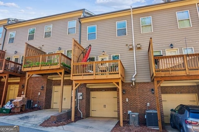 7420 Glisten Ave, Sandy Springs, GA 30328 - back of property with brick siding, central AC, an attached garage, and a balcony
