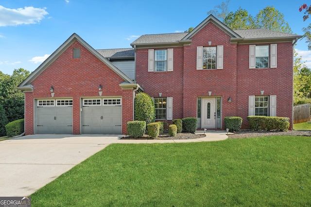 colonial inspired home featuring a garage, concrete driveway, brick siding, and a front lawn