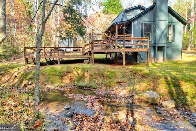 rear view of property with a yard and a deck