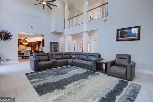 8910 Champion Ct, Ball Ground, GA 30107 - living room featuring a high ceiling, a ceiling fan, baseboards, arched walkways, and carpet flooring
