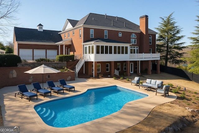 8910 Champion Ct, Ball Ground, GA 30107 - rear view of house featuring a patio area, a chimney, stairway, outdoor lounge area, and a sunroom