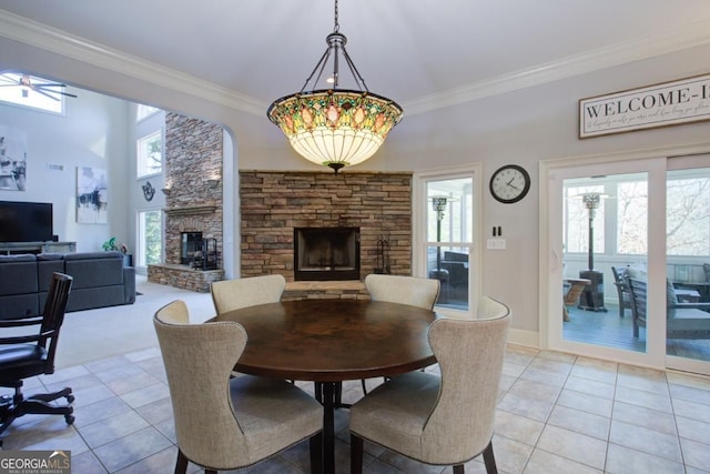 8910 Champion Ct, Ball Ground, GA 30107 - dining space with a stone fireplace, light tile patterned flooring, crown molding, and ceiling fan