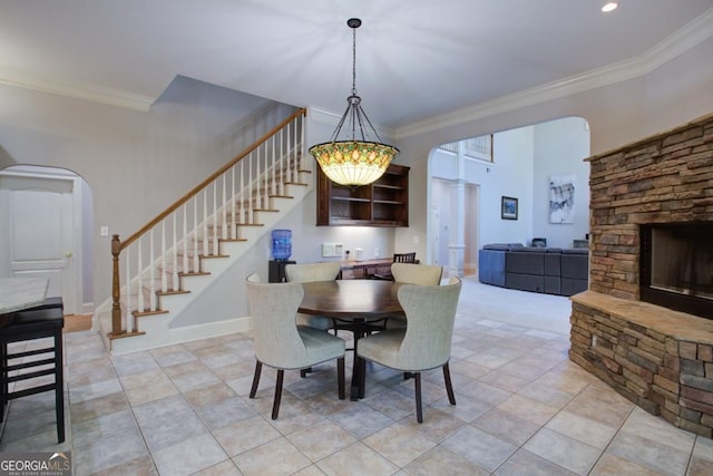 8910 Champion Ct, Ball Ground, GA 30107 - dining area featuring stairway, arched walkways, ornamental molding, a stone fireplace, and light tile patterned flooring