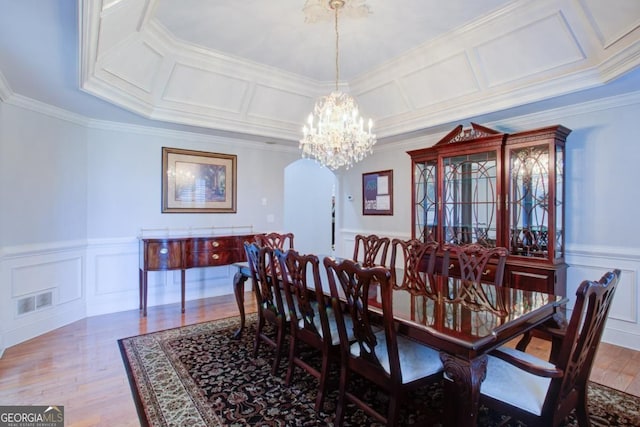 8910 Champion Ct, Ball Ground, GA 30107 - dining area with arched walkways, wood finished floors, ornamental molding, a decorative wall, and a chandelier