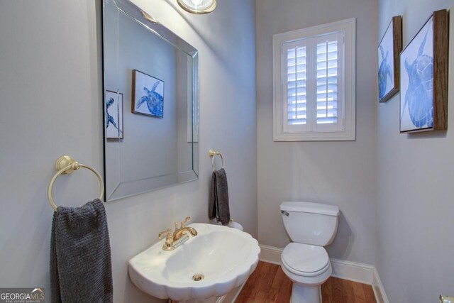 8910 Champion Ct, Ball Ground, GA 30107 - half bathroom with toilet, a sink, baseboards, and wood finished floors