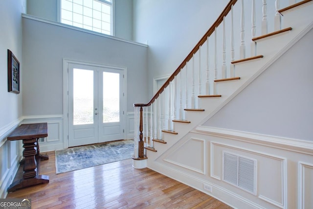 entryway featuring light wood-style floors, a wealth of natural light, french doors, and visible vents