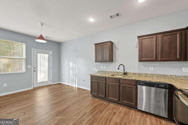 kitchen featuring visible vents, decorative light fixtures, dark brown cabinets, stainless steel dishwasher, and a sink