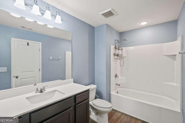 full bathroom with toilet, shower / bath combination, wood finished floors, and visible vents