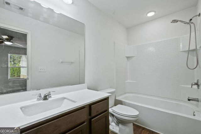 bathroom with toilet, wood finished floors, visible vents, vanity, and  shower combination