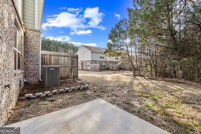 view of yard with central AC, a patio, and fence