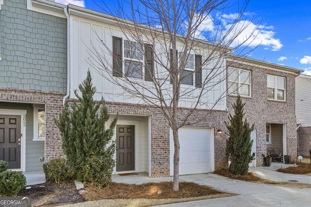 multi unit property featuring concrete driveway, brick siding, and an attached garage