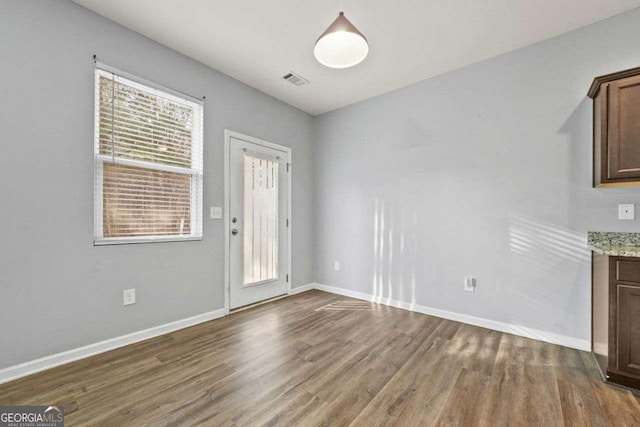 interior space featuring dark wood-type flooring, visible vents, and baseboards