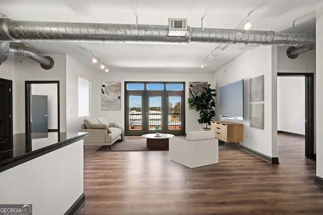 living room with dark wood-style flooring, rail lighting, and visible vents