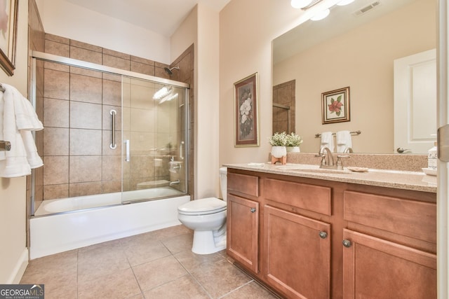 bathroom featuring visible vents, toilet, tile patterned floors, combined bath / shower with glass door, and vanity