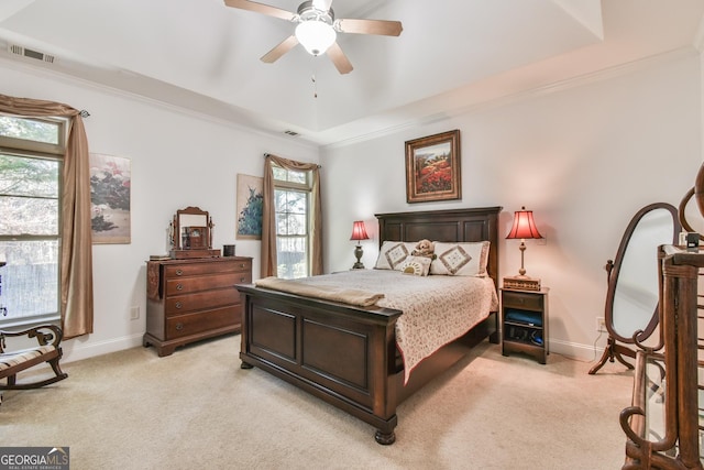 bedroom with visible vents, a raised ceiling, and light colored carpet