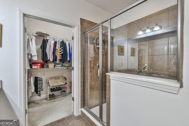 bathroom featuring a stall shower, tile patterned flooring, and a spacious closet