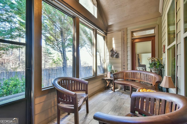 sunroom featuring plenty of natural light and vaulted ceiling