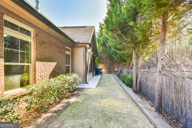 view of home's exterior with fence and brick siding