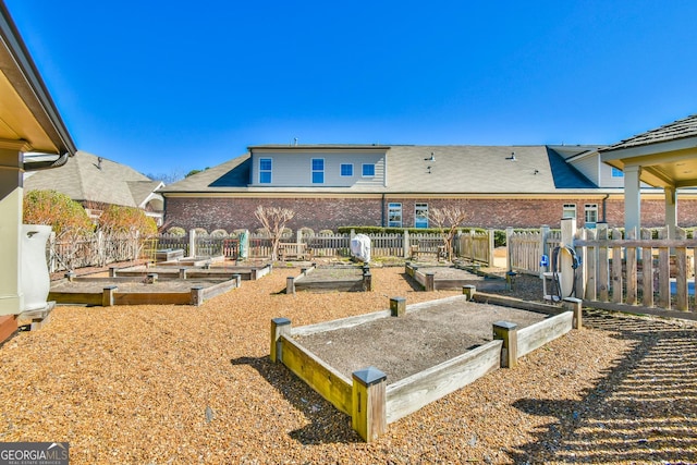 surrounding community featuring a vegetable garden and fence