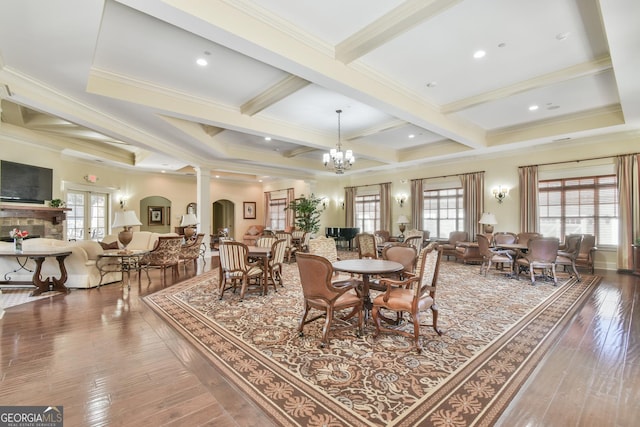 dining room with coffered ceiling, beam ceiling, a healthy amount of sunlight, and wood finished floors