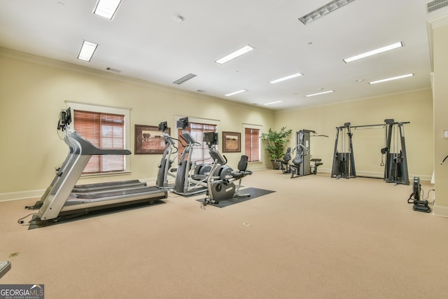 exercise room with visible vents, ornamental molding, and baseboards