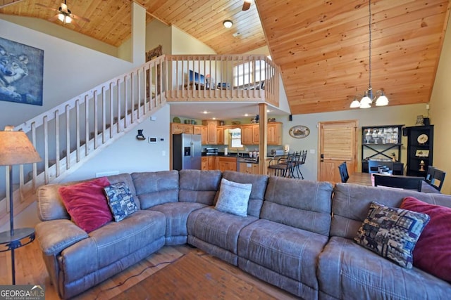 living area with stairs, wooden ceiling, high vaulted ceiling, and ceiling fan with notable chandelier