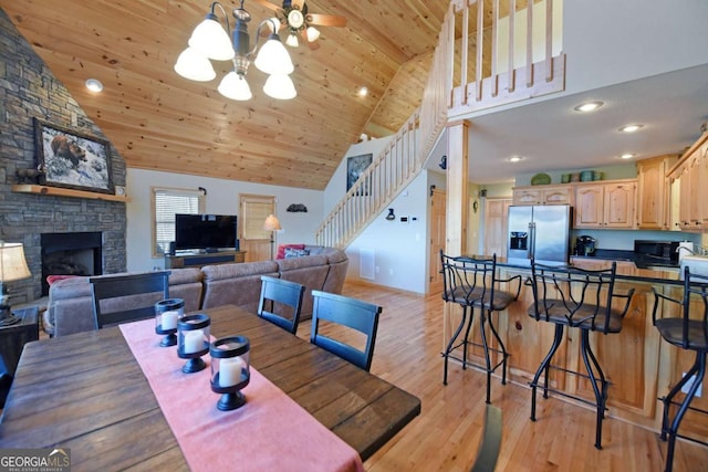 dining area with wooden ceiling, stairway, light wood-type flooring, a fireplace, and high vaulted ceiling