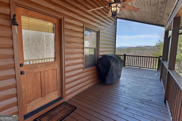 wooden terrace with a porch, area for grilling, and a ceiling fan