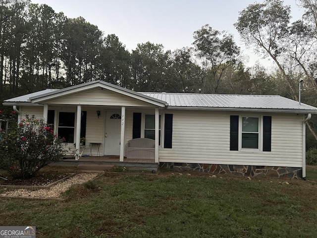 view of front of home with crawl space, metal roof, covered porch, and a front lawn