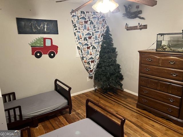 bedroom with baseboards and wood finished floors