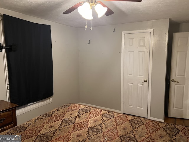 unfurnished bedroom with a ceiling fan, baseboards, and a textured ceiling