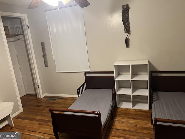 bedroom featuring baseboards, wood-type flooring, and ceiling fan