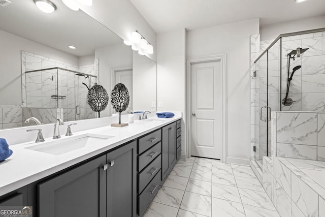 full bathroom featuring marble finish floor, double vanity, a sink, and a shower stall