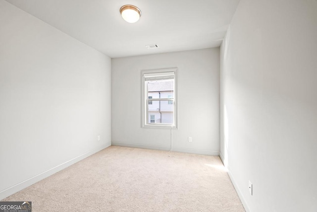 spare room with light carpet, baseboards, and visible vents