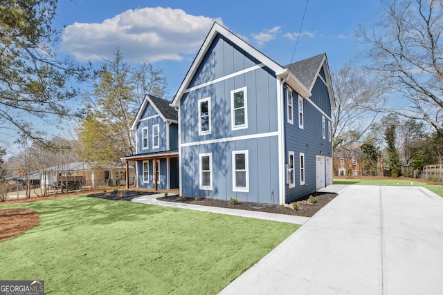 view of front of property with board and batten siding, a shingled roof, a front lawn, and fence