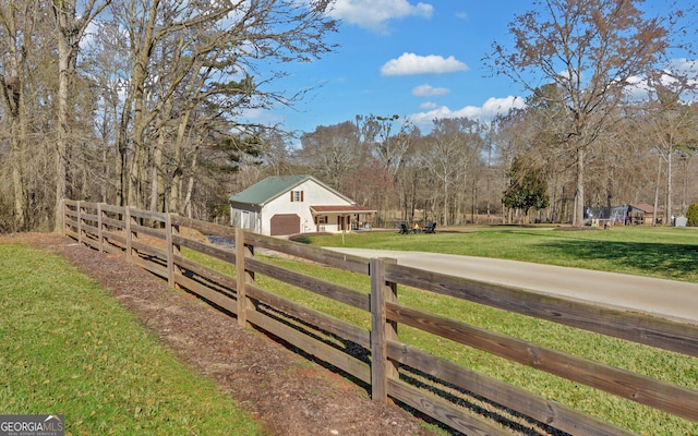 view of yard with a garage, an outbuilding, and fence