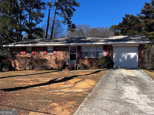 single story home with a garage, concrete driveway, brick siding, and crawl space