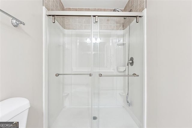 full bath with a stall shower and toilet