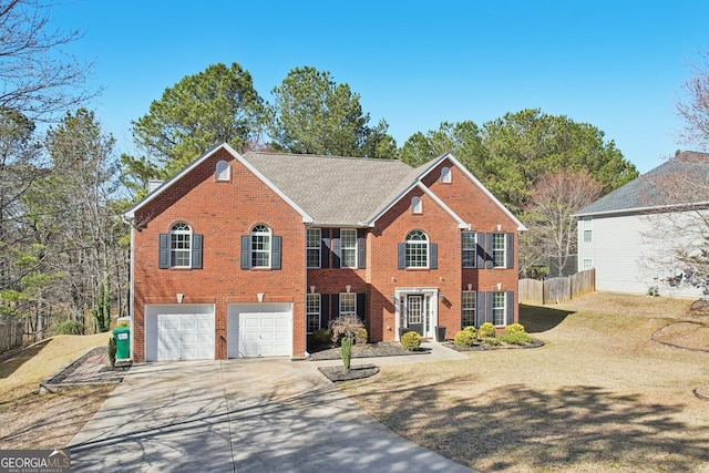 colonial house with concrete driveway, brick siding, an attached garage, and fence