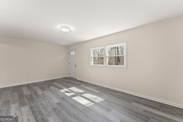 unfurnished room with wood finished floors and baseboards