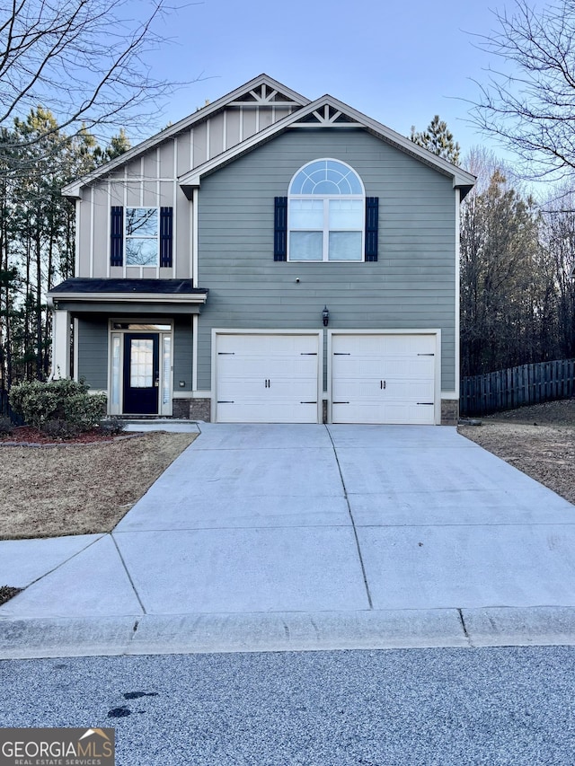 traditional-style home with board and batten siding, concrete driveway, fence, and an attached garage