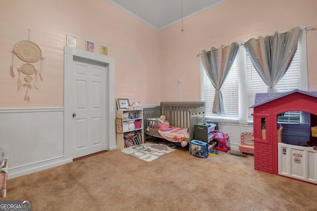 bedroom featuring a wainscoted wall, a high ceiling, carpet flooring, and crown molding