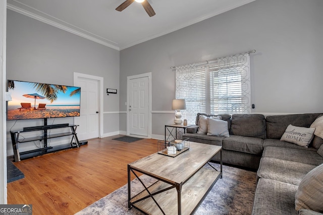 living room with ceiling fan, ornamental molding, wood finished floors, and baseboards