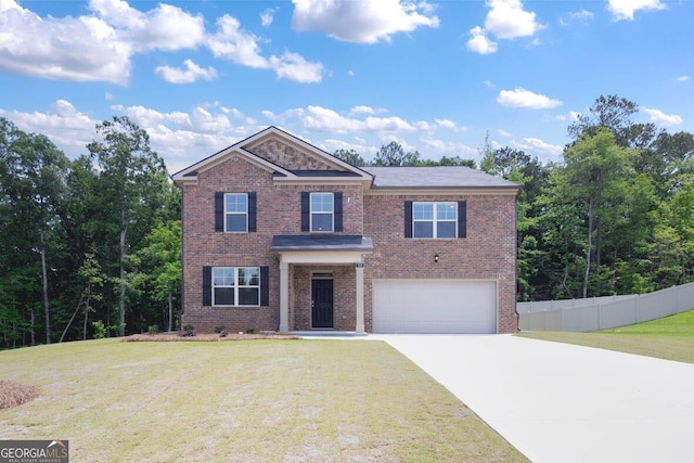 view of front of house with an attached garage, brick siding, a front yard, and fence