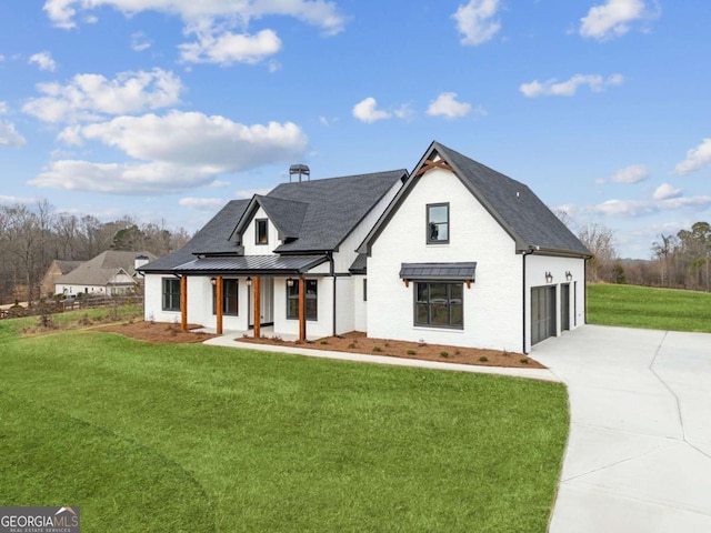 view of front facade featuring driveway, a standing seam roof, a porch, and a front lawn