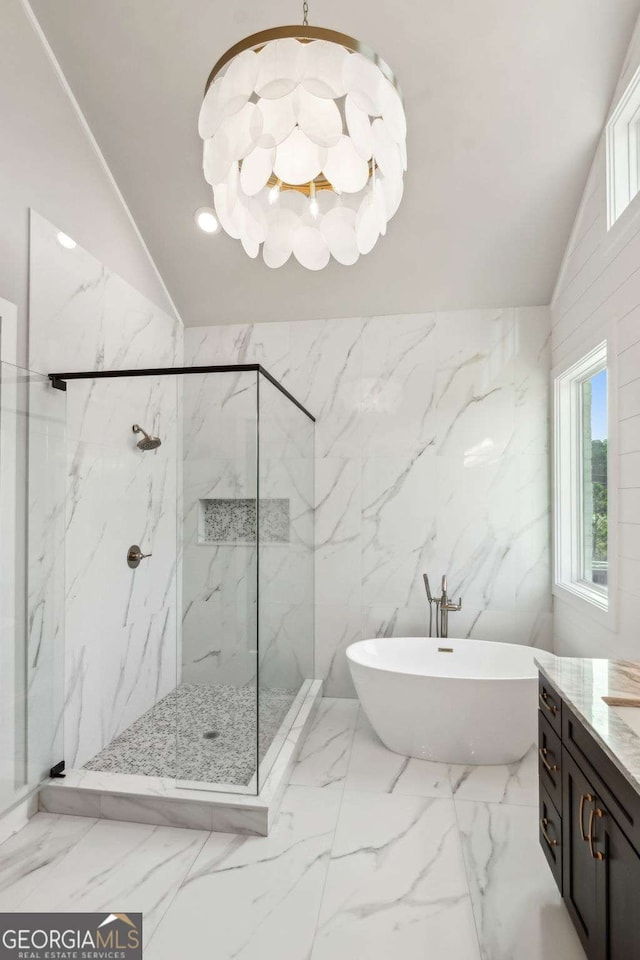 bathroom featuring a marble finish shower, a soaking tub, marble finish floor, vaulted ceiling, and a chandelier