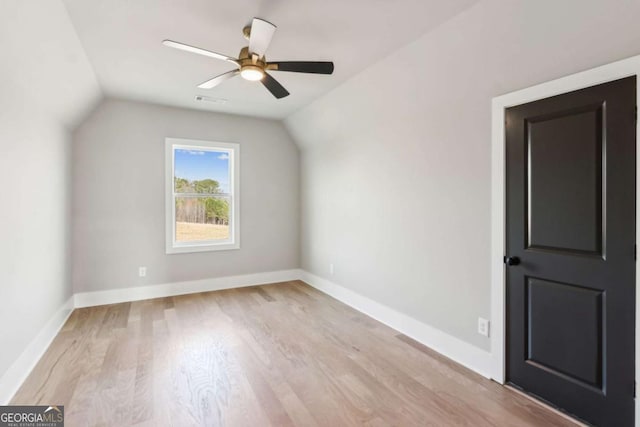 additional living space featuring visible vents, baseboards, ceiling fan, vaulted ceiling, and light wood-type flooring