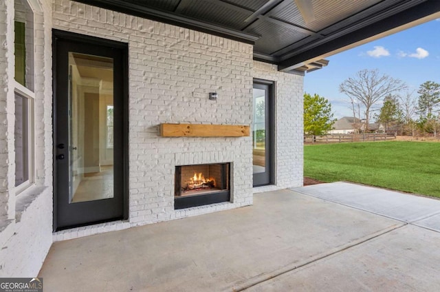 view of patio / terrace featuring an outdoor brick fireplace and fence