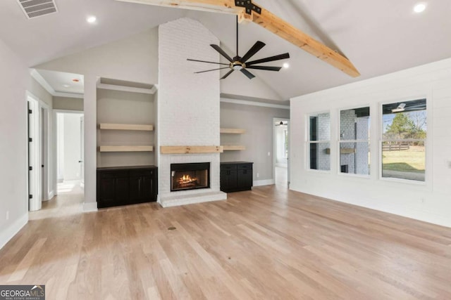 unfurnished living room featuring visible vents, a brick fireplace, ceiling fan, light wood-type flooring, and beamed ceiling